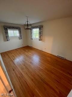 2840 Brian Dr, Parma, OH 44134 - unfurnished dining area featuring wood finished floors, a chandelier, and healthy amount of natural light