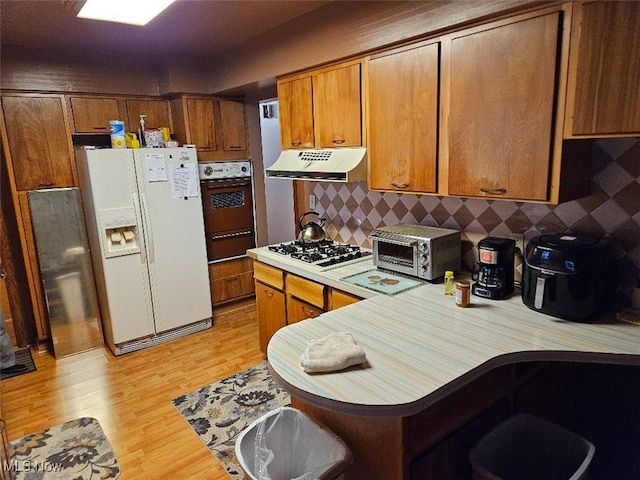 1217 Ada St, Akron, OH 44306 - kitchen with white appliances, under cabinet range hood, light wood-type flooring, light countertops, and a warming drawer