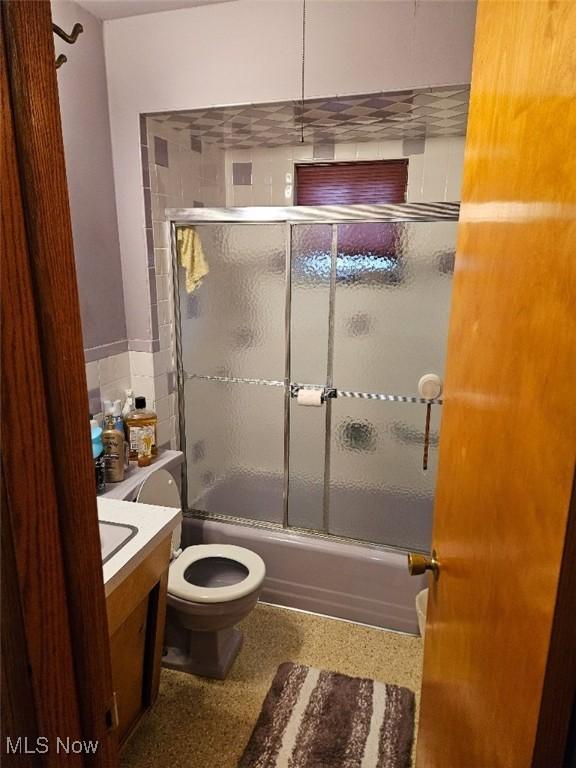 1217 Ada St, Akron, OH 44306 - full bathroom featuring toilet, combined bath / shower with glass door, vanity, and speckled floor