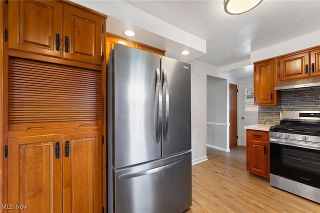3005 Algonquin Dr, Poland, OH 44514 - kitchen with stainless steel appliances, under cabinet range hood, baseboards, decorative backsplash, and light wood-style flooring