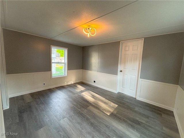 11 Redwood Dr, Beloit, OH 44609 - unfurnished room with a wainscoted wall and dark wood-type flooring