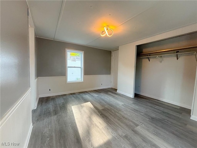 11 Redwood Dr, Beloit, OH 44609 - unfurnished bedroom featuring wood finished floors, a closet, and a wainscoted wall
