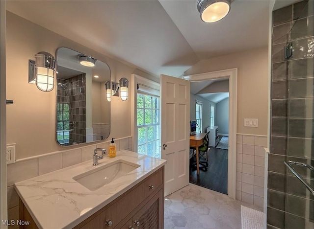22099 Shaker Blvd, Shaker Heights, OH 44122 - bathroom with vaulted ceiling, vanity, tile walls, a wainscoted wall, and tiled shower