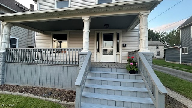 view of exterior entry featuring covered porch