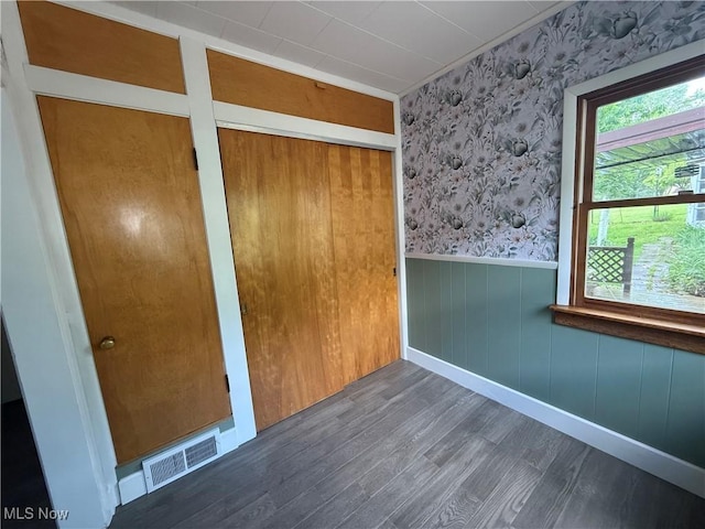 1707 Clairmont Ave, Cambridge, OH 43725 - unfurnished bedroom with wallpapered walls, wood finished floors, a wainscoted wall, and baseboards