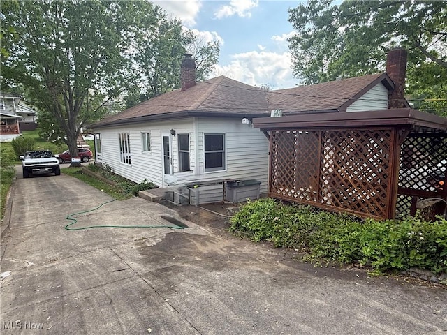 1707 Clairmont Ave, Cambridge, OH 43725 - view of home's exterior featuring a chimney, roof with shingles, and driveway