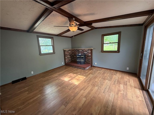 1707 Clairmont Ave, Cambridge, OH 43725 - unfurnished living room with wood finished floors, ceiling fan, baseboards, and a wood stove