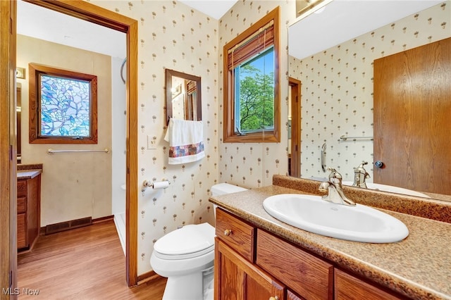 33 Brandon Pl, Rocky River, OH 44116 - bathroom featuring wood finished floors, wallpapered walls, vanity, toilet, and baseboards