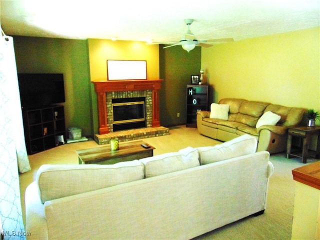 living room featuring ceiling fan and a glass covered fireplace