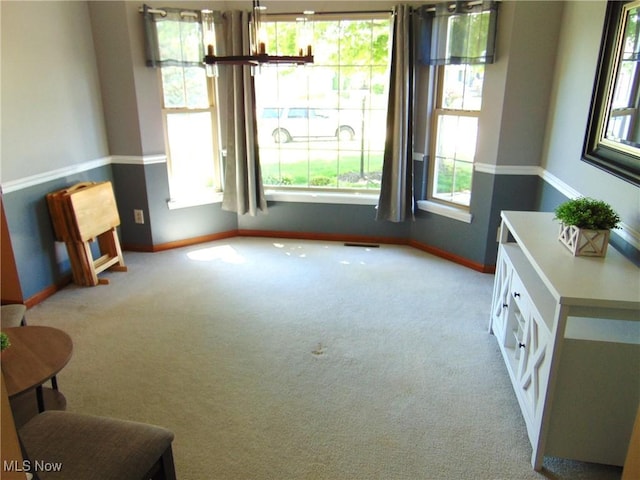 sitting room featuring baseboards, carpet floors, and a chandelier