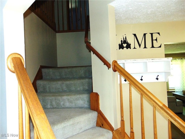 stairs featuring a textured ceiling