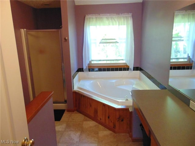 bathroom with a garden tub, a shower stall, and tile patterned flooring
