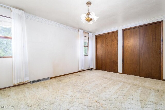 128 E Circle Dr, Weirton, WV 26062 - unfurnished bedroom with two closets, carpet, and a chandelier