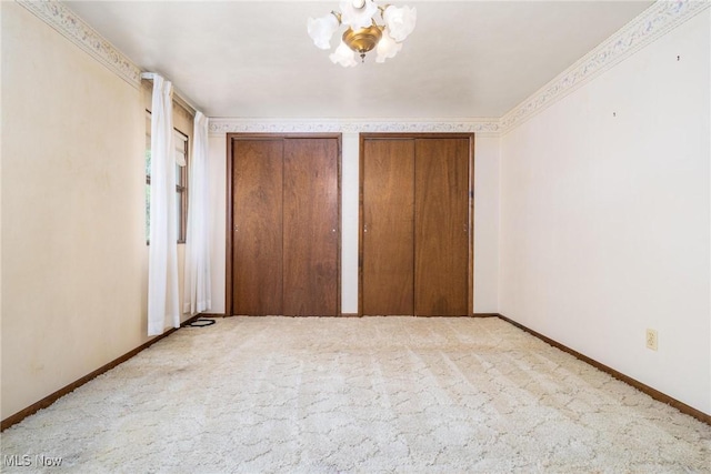 128 E Circle Dr, Weirton, WV 26062 - unfurnished bedroom featuring a chandelier, multiple closets, carpet floors, and baseboards