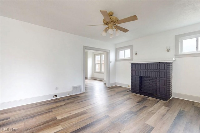 520 Lincoln Blvd, Steubenville, OH 43952 - unfurnished living room with plenty of natural light, a ceiling fan, wood finished floors, and a brick fireplace