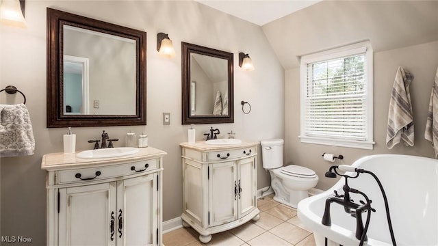 1251 Marwood Dr, Zanesville, OH 43701 - full bathroom featuring a freestanding tub, two vanities, tile patterned flooring, baseboards, and toilet