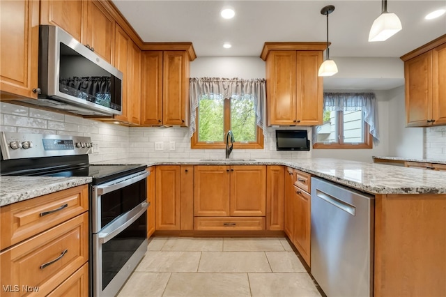 7456 Blue Ridge Dr, Mentor, OH 44060 - kitchen featuring appliances with stainless steel finishes, a sink, decorative backsplash, a peninsula, and light stone counters
