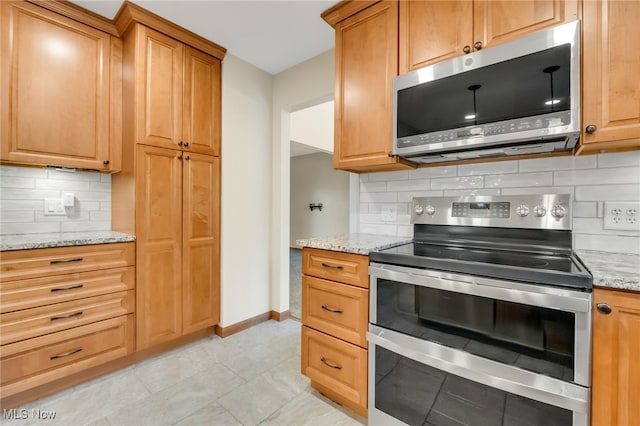 7456 Blue Ridge Dr, Mentor, OH 44060 - kitchen featuring appliances with stainless steel finishes, decorative backsplash, baseboards, and light stone countertops