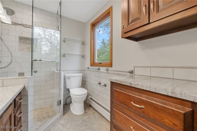 7456 Blue Ridge Dr, Mentor, OH 44060 - full bathroom featuring baseboard heating, vanity, tile walls, a stall shower, and toilet