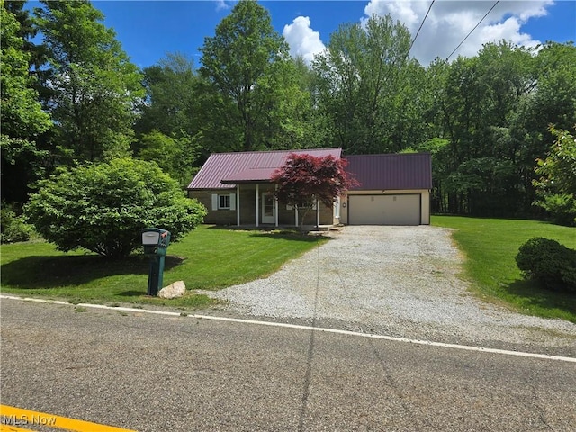 355 N Elm Ave, Tallmadge, OH 44278 - view of front facade featuring metal roof, a front lawn, gravel driveway, and a garage