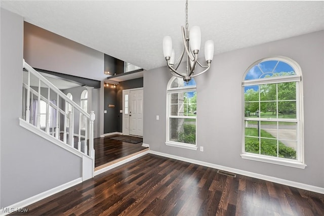 4474 Litchfield Dr, Copley, OH 44321 - foyer entrance with a chandelier, wood finished floors, stairs, healthy amount of natural light, and a textured ceiling
