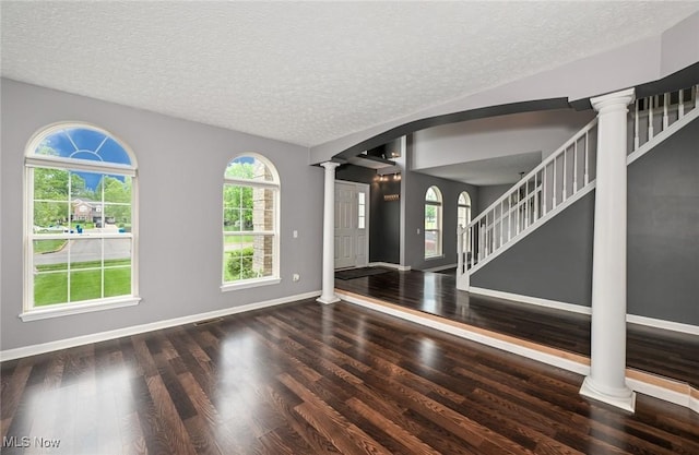 4474 Litchfield Dr, Copley, OH 44321 - unfurnished living room with decorative columns, wood finished floors, a textured ceiling, and plenty of natural light