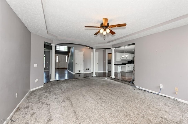 4474 Litchfield Dr, Copley, OH 44321 - unfurnished living room featuring decorative columns, baseboards, a textured ceiling, ceiling fan, and carpet flooring
