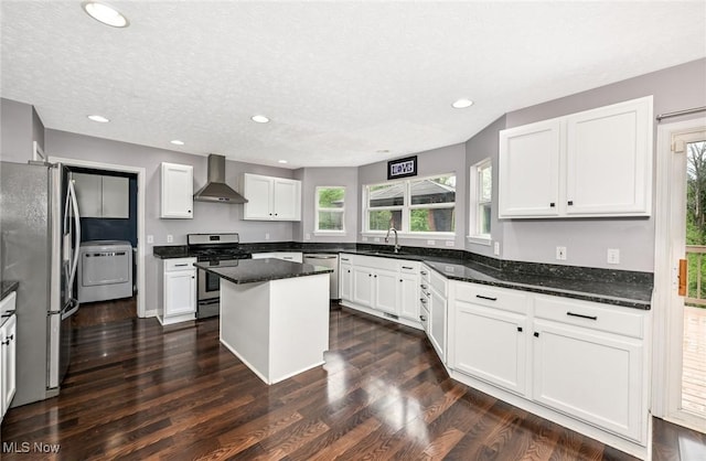 4474 Litchfield Dr, Copley, OH 44321 - kitchen featuring appliances with stainless steel finishes, wall chimney range hood, washer / clothes dryer, recessed lighting, and a center island