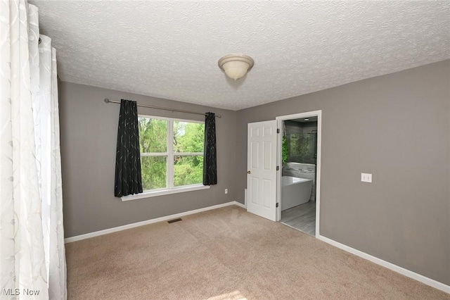 4474 Litchfield Dr, Copley, OH 44321 - unfurnished bedroom featuring baseboards, carpet flooring, ensuite bath, and a textured ceiling