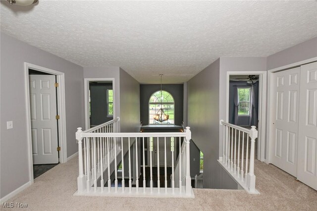 4474 Litchfield Dr, Copley, OH 44321 - corridor featuring an upstairs landing, carpet flooring, baseboards, and a textured ceiling