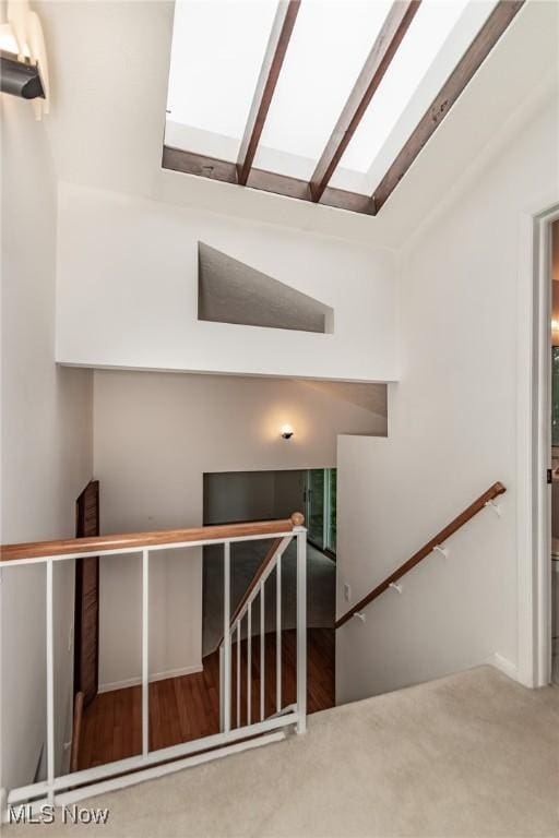 12562 Harold Dr, Chesterland, OH 44026 - stairway featuring a skylight, lofted ceiling, and carpet flooring