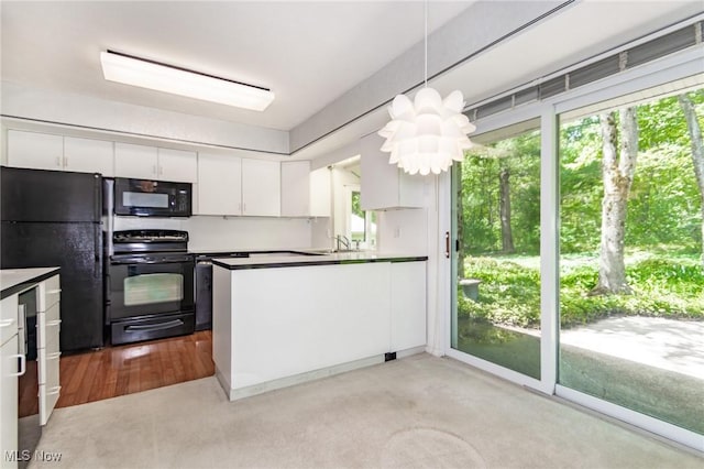 12562 Harold Dr, Chesterland, OH 44026 - kitchen featuring black appliances, white cabinets, a sink, and a peninsula