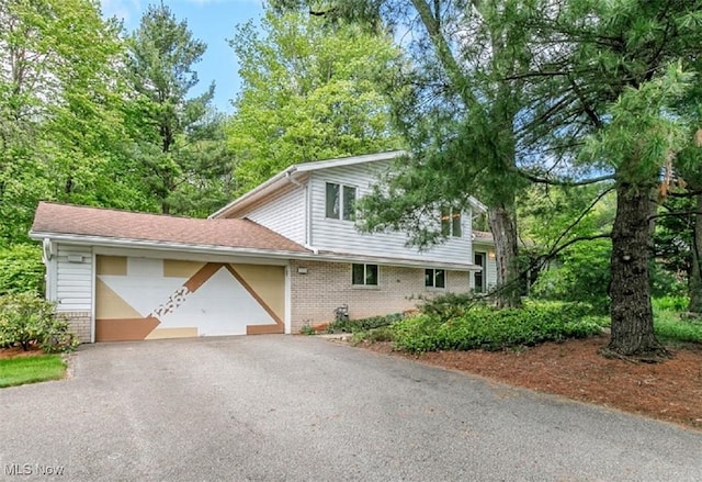 12562 Harold Dr, Chesterland, OH 44026 - tri-level home with brick siding, asphalt driveway, and an attached garage