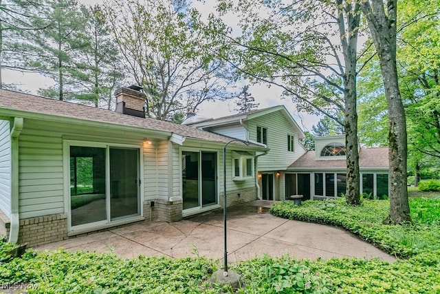 12562 Harold Dr, Chesterland, OH 44026 - back of property with a patio area, a chimney, brick siding, and a shingled roof