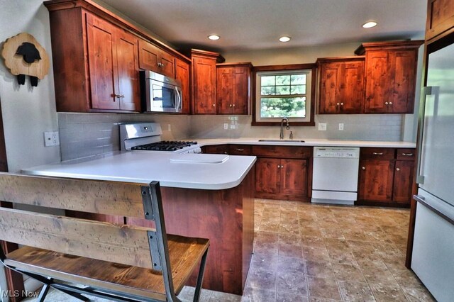 24514 County Road 24, Coshocton, OH 43812 - kitchen featuring white appliances, a sink, light countertops, backsplash, and recessed lighting