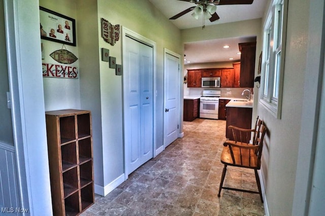 24514 County Road 24, Coshocton, OH 43812 - kitchen featuring white range with gas cooktop, stainless steel microwave, ceiling fan, a sink, and light countertops