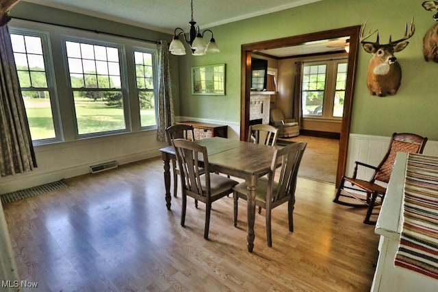 24514 County Road 24, Coshocton, OH 43812 - dining space with wood finished floors, healthy amount of natural light, a chandelier, a wainscoted wall, and ornamental molding