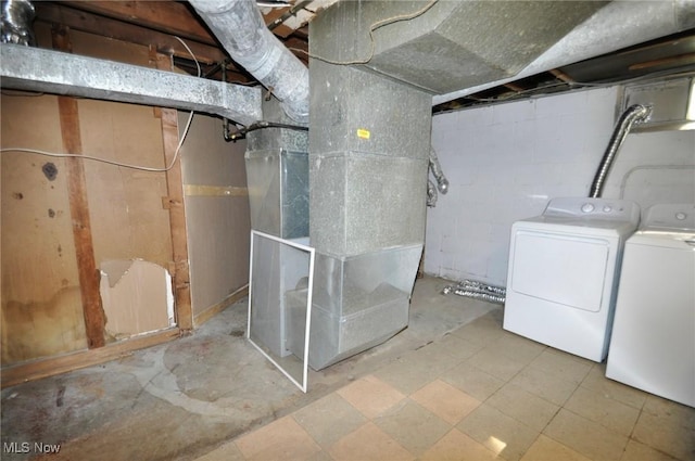 unfinished basement with washer and clothes dryer and heating unit