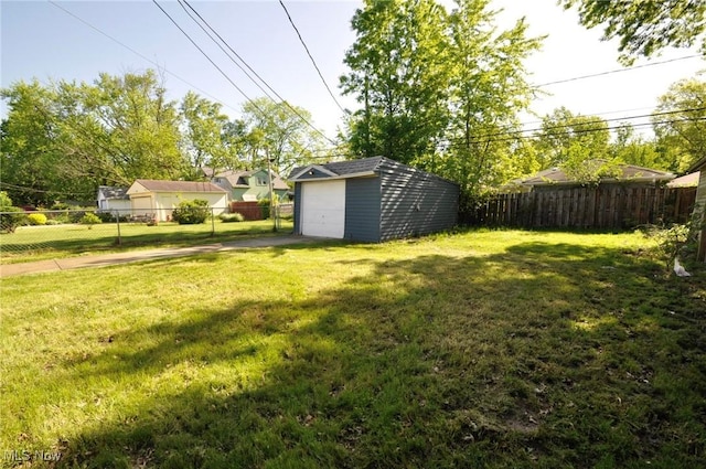 view of yard featuring a garage, an outdoor structure, and driveway