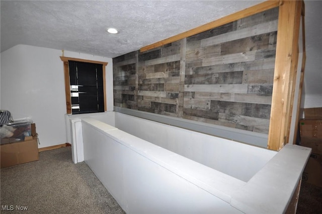 hallway featuring recessed lighting, a textured ceiling, carpet floors, and baseboards