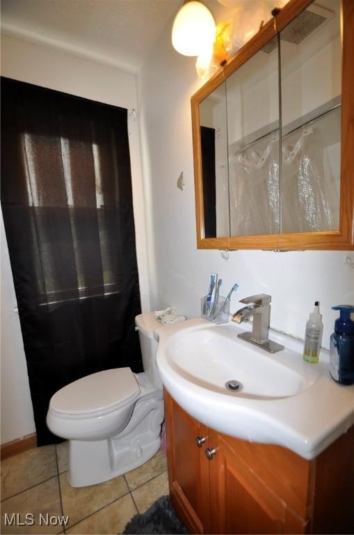 bathroom with tile patterned floors, vanity, and toilet