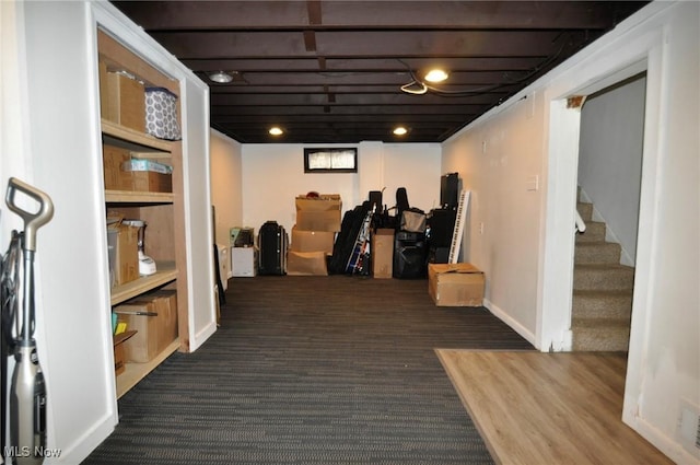 finished basement with carpet floors, stairs, and baseboards
