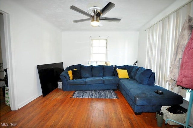 living room with wood finished floors, ceiling fan, and baseboards