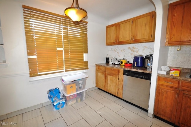 kitchen featuring stainless steel dishwasher, tasteful backsplash, brown cabinets, and pendant lighting