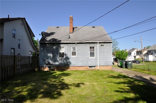 back of property featuring roof with shingles, a chimney, and a residential view