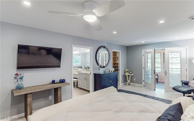 bedroom featuring recessed lighting, baseboards, ensuite bath, a walk in closet, and a ceiling fan