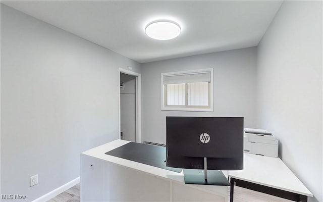 unfurnished office with baseboards and wood finished floors