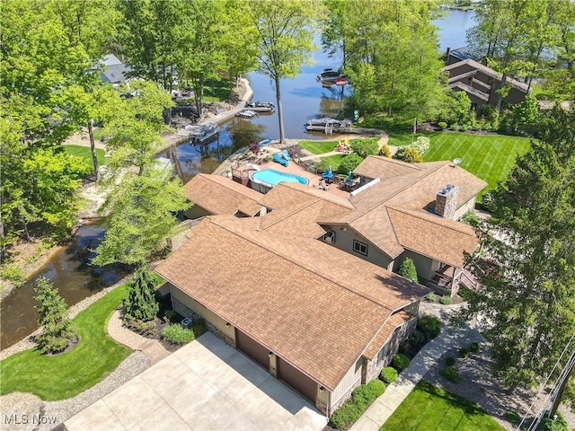 aerial view of property and surrounding area featuring a nearby body of water and a pool