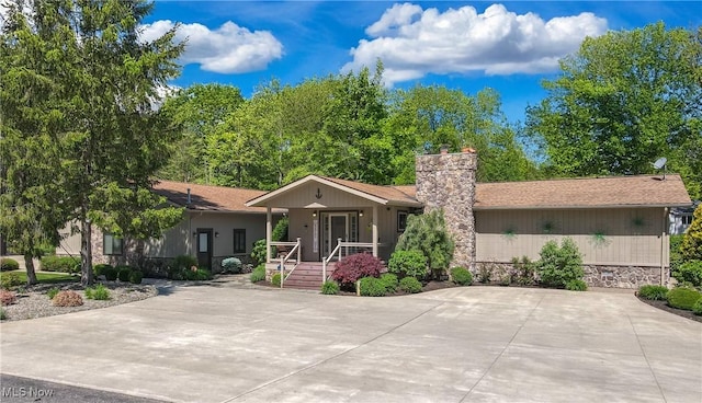 single story home featuring a chimney and a porch
