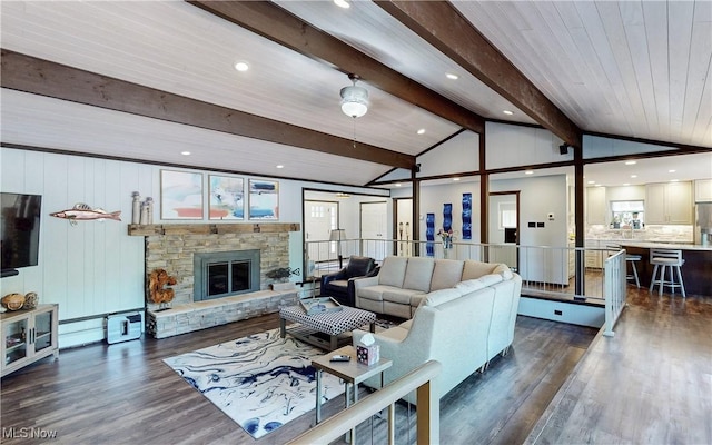 living room with dark wood-style flooring, recessed lighting, and a stone fireplace